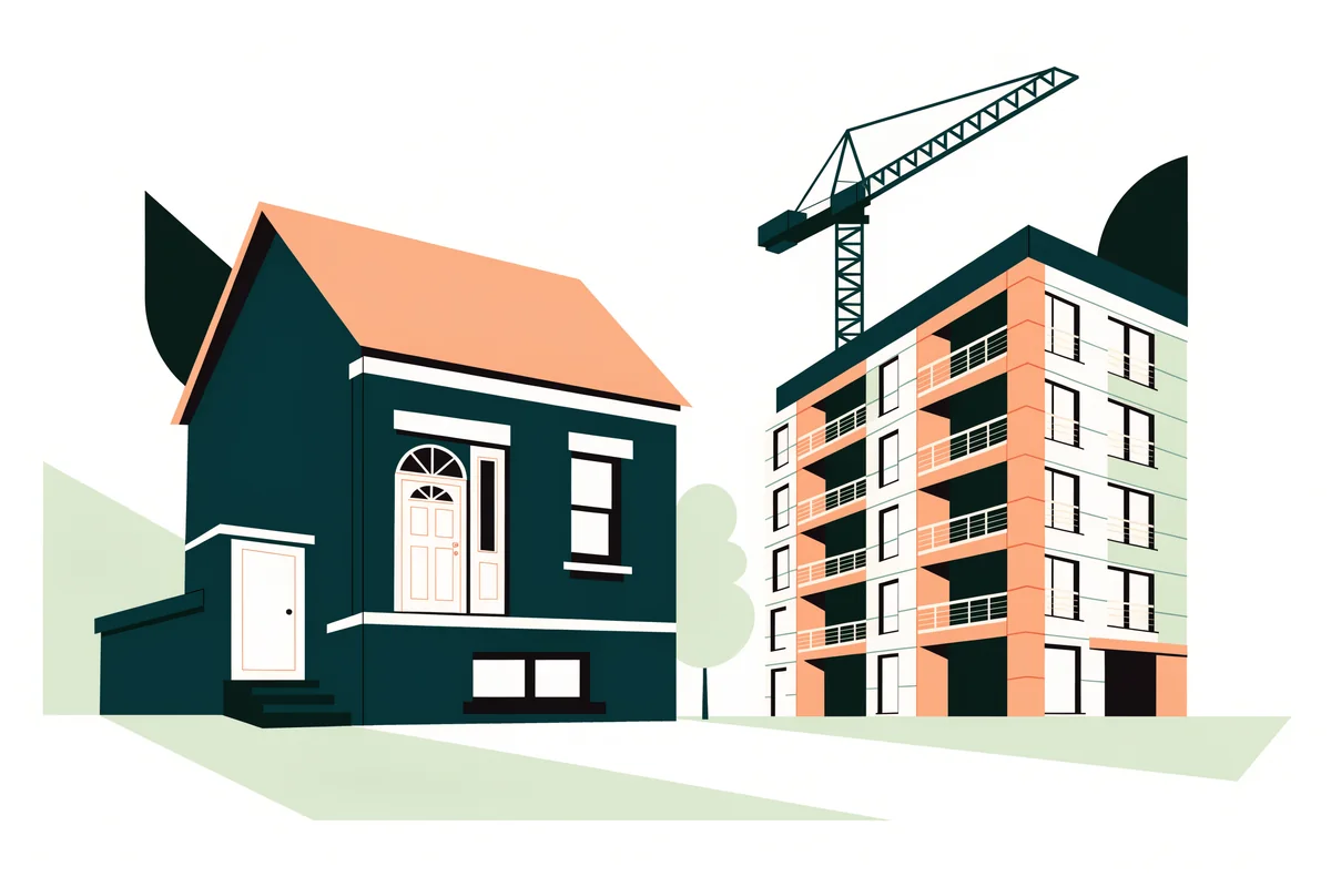 An older house beside a new apartment building with a construction crane behind it.